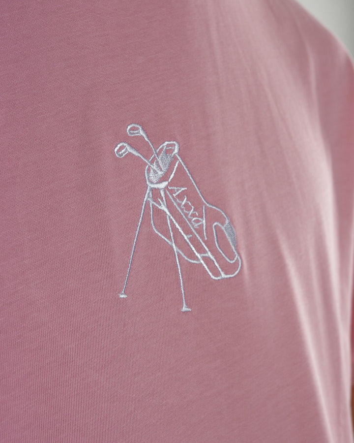 Pink t-shirt with a white graphic of a golf club and bag on a plain background